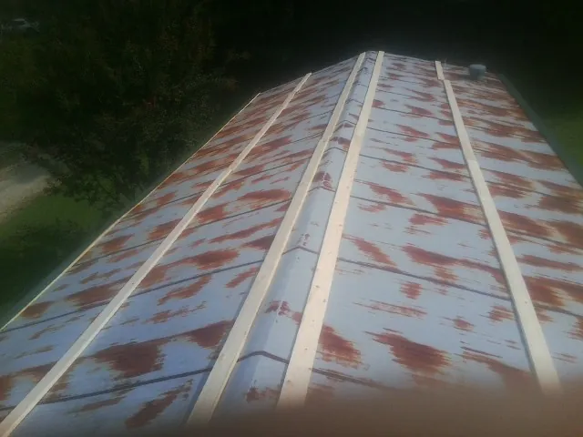 Rusted metal roof panels with new wood purlins before replacement — Storm Damage Roof Repair in Eleva by Roofing Brothers